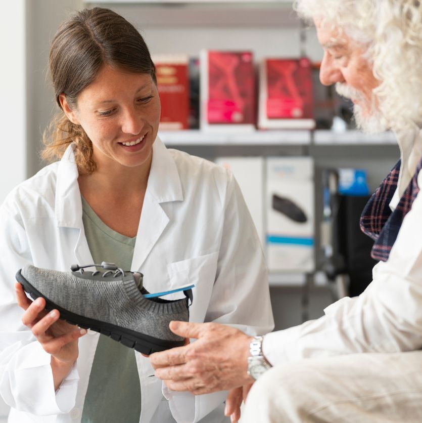 man choosing a pair of diabetic shoes with a doctor